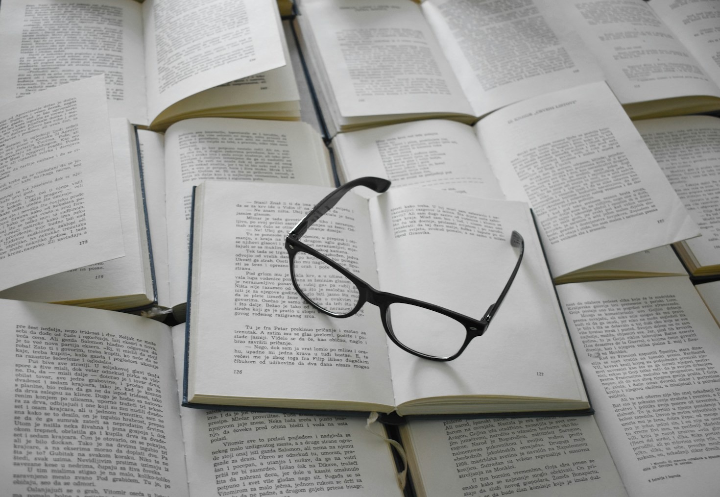 dark pair of glasses on top of open books