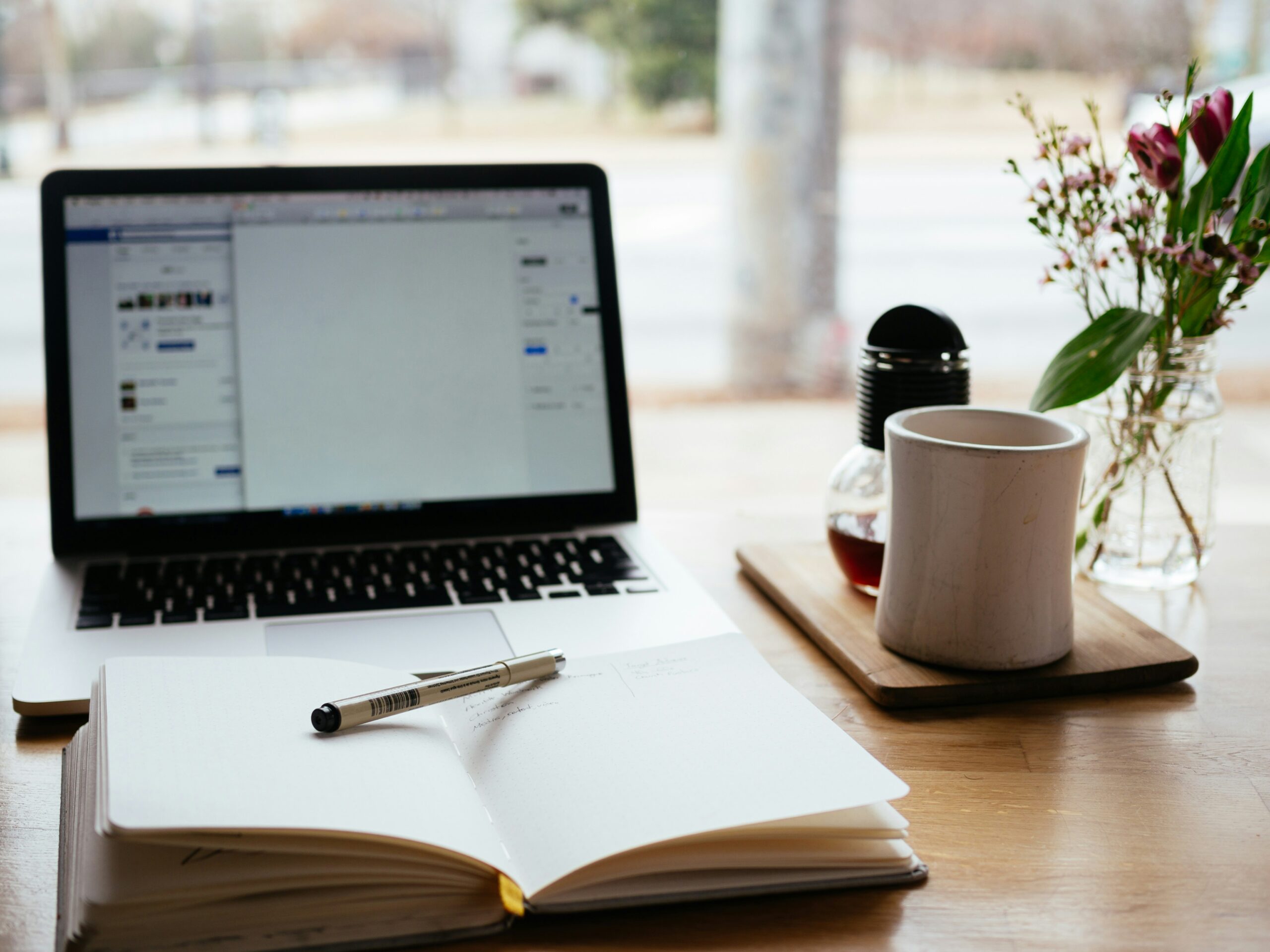 open journal in front of laptop - cozy writing nook
